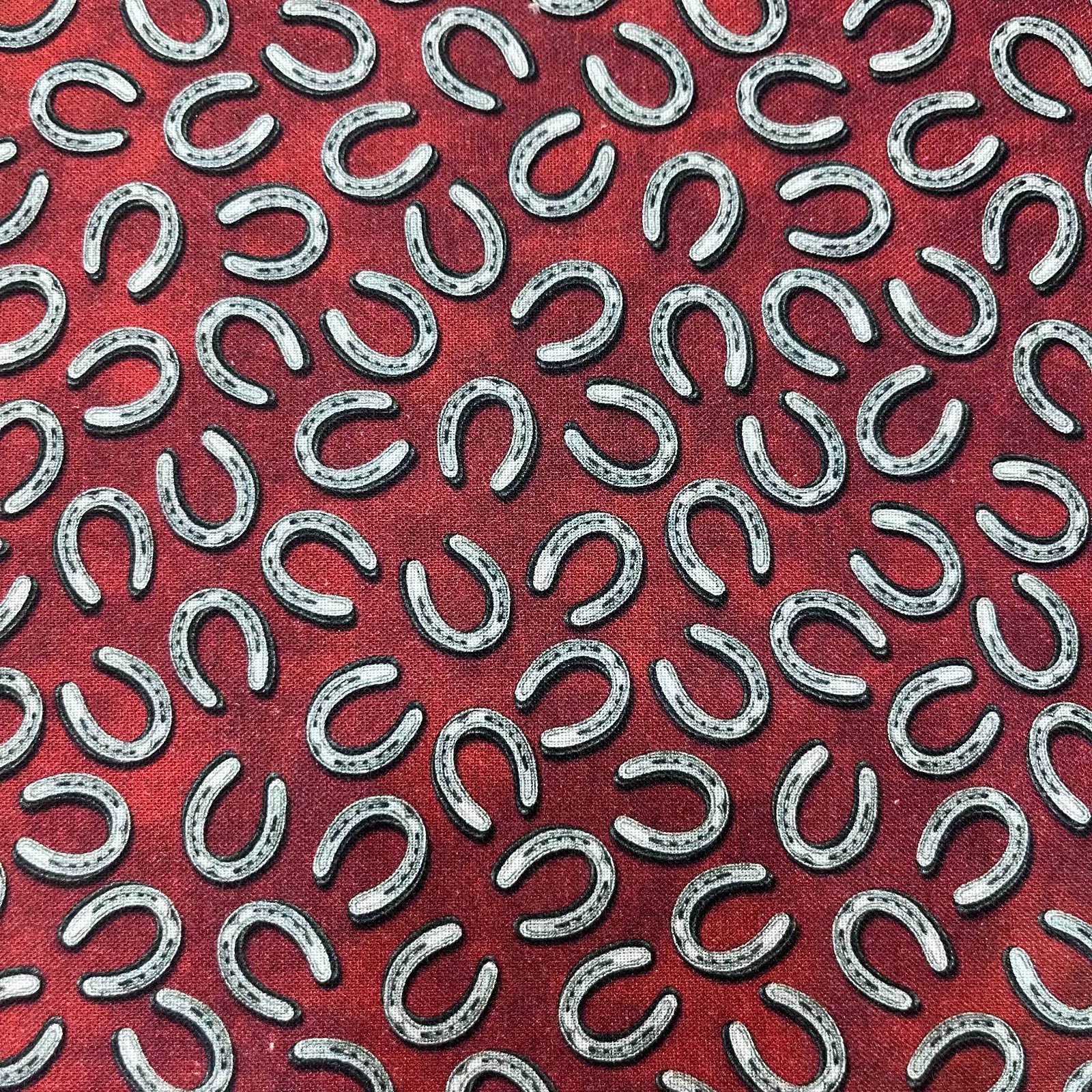 Pattern of silver horseshoes on a red background